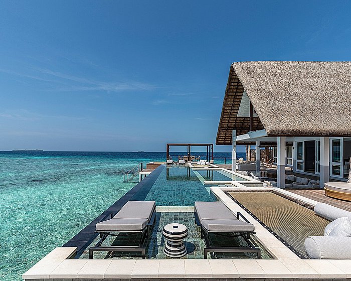 Aerial view of luxury overwater villas at Four Seasons Resort Maldives at Landaa Giraavaru