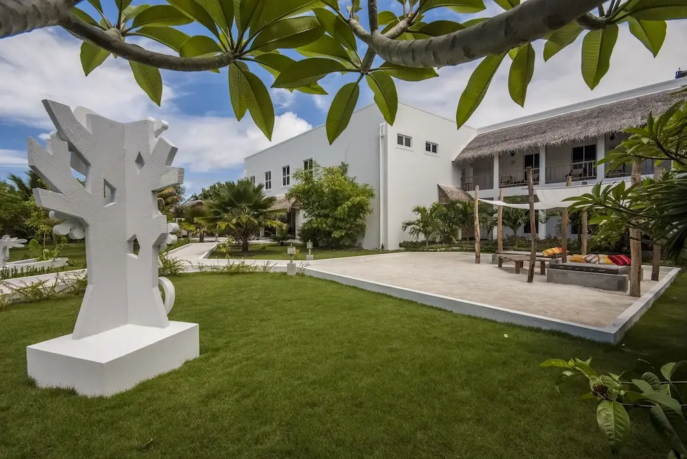 Exterior view of Amra Palace Laamu, a luxury resort in Gan Island, Laamu Atoll, Maldives, showcasing tropical architecture and lush greenery.