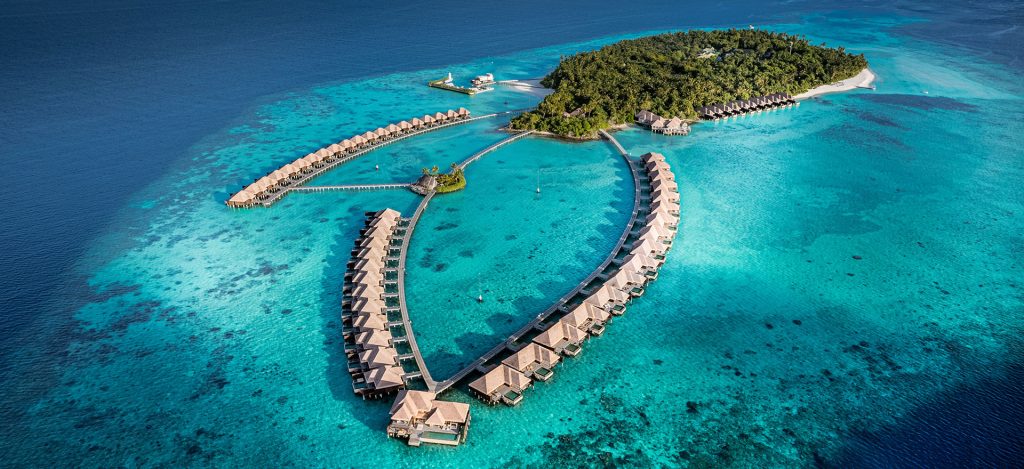 Aerial view of luxury overwater bungalows at Ayada Maldives, a top-rated adults-only honeymoon resort featuring turquoise lagoons and private pools.