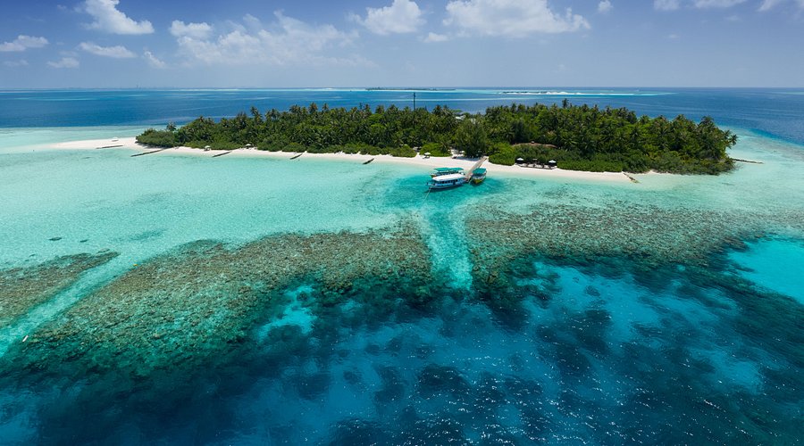 Aerial view of a budget-friendly honeymoon resort in Maldives with turquoise water, white sand beach, and a tropical island for couples.