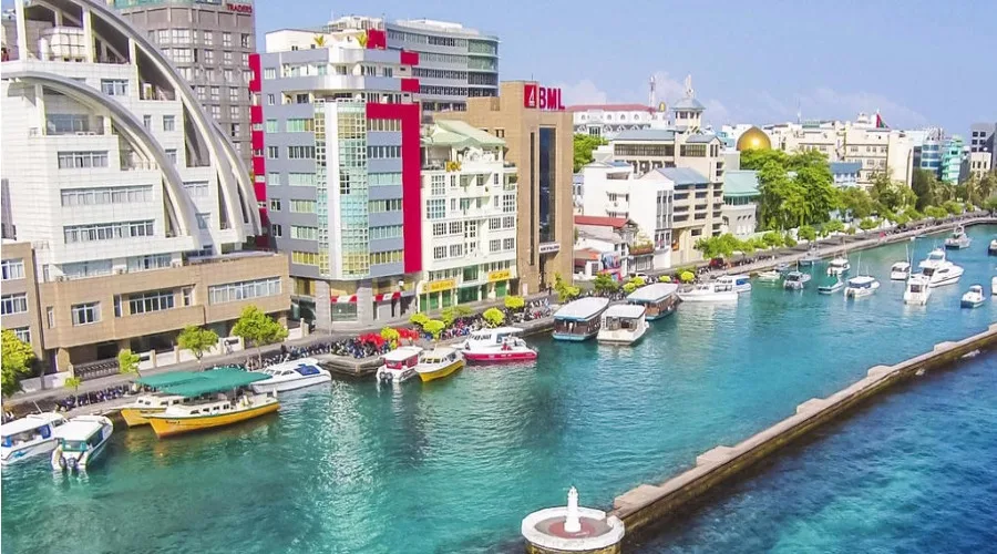 Panoramic view of the vibrant Malé city waterfront with colorful buildings and boats in Maldives.