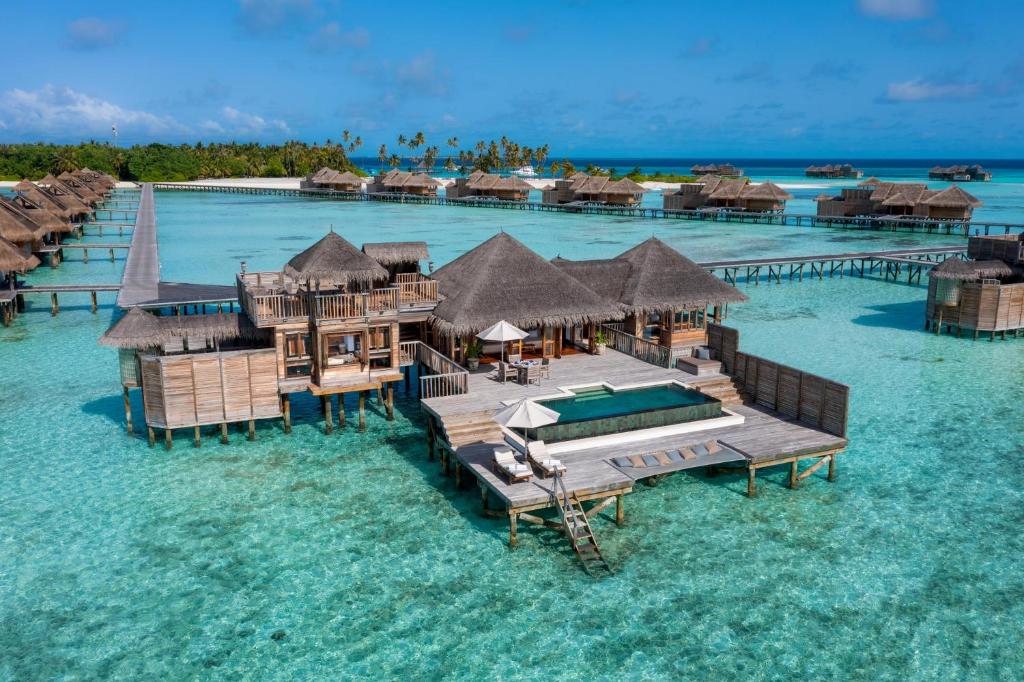 Luxury overwater honeymoon villa with a private infinity pool at Gili Lankanfushi resort in Maldives, surrounded by turquoise ocean water.