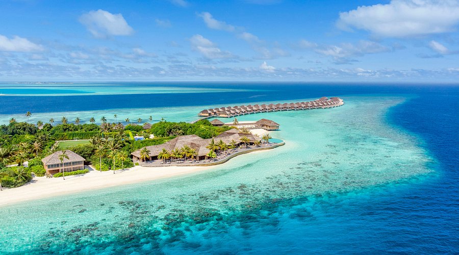 Aerial view of Hurawalhi Island Resort in Maldives featuring luxury overwater villas, white sandy beaches, and turquoise ocean water—perfect for an adults-only honeymoon.