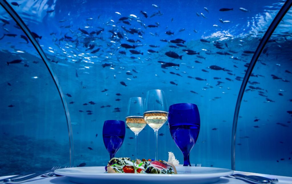 Couple dining 5.8 meters underwater at Hurawalhi Island Resort, a top Instagrammable honeymoon spot in the Maldives.