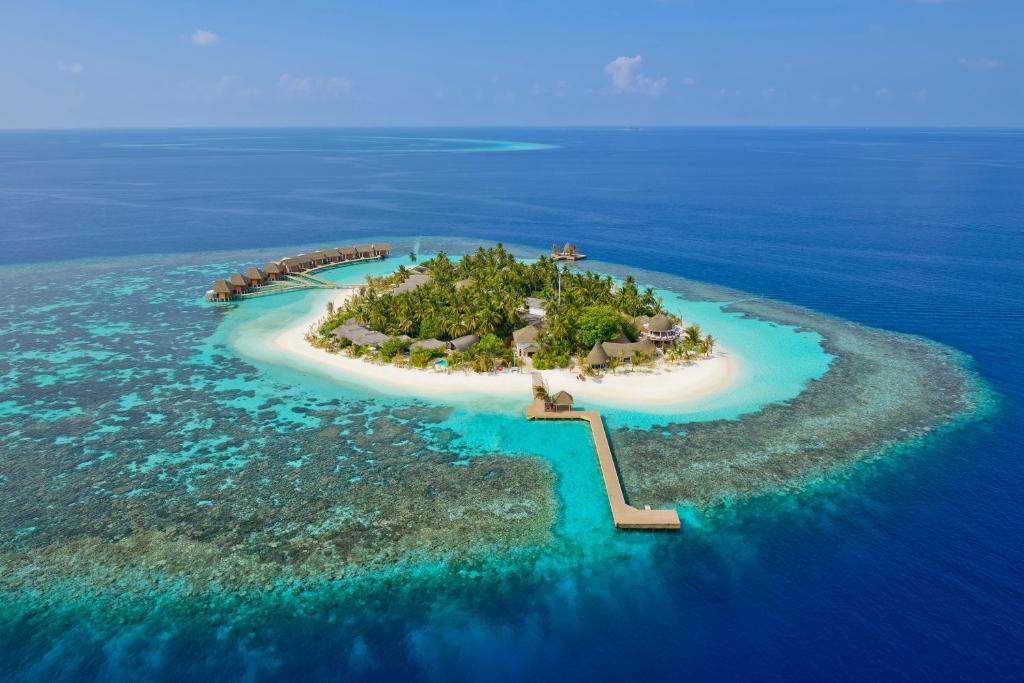Aerial view of Kandolhu Maldives resort with turquoise lagoon and luxury overwater villas for a romantic honeymoon.
