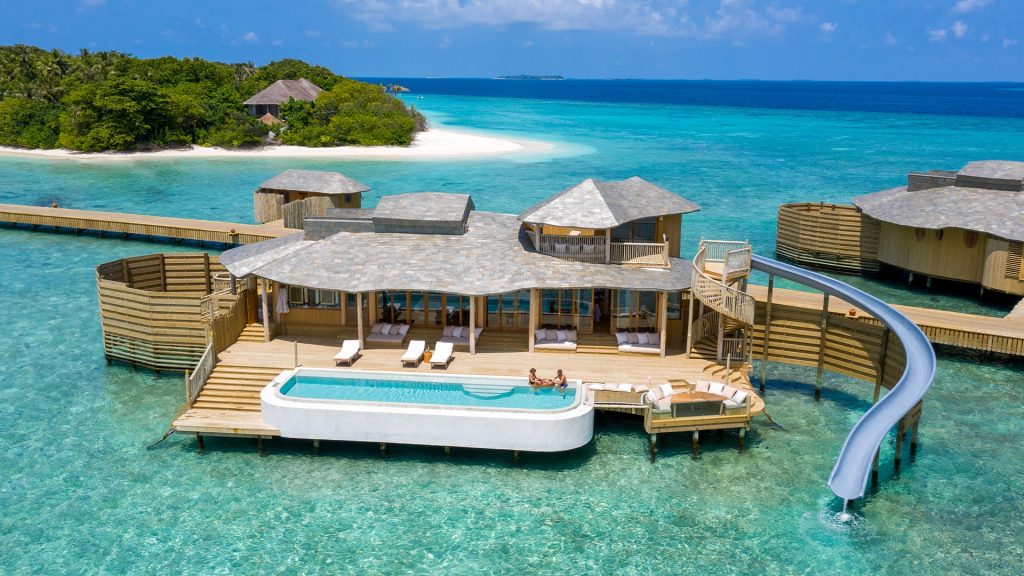 Luxury overwater villa in Baa Atoll Maldives featuring a private pool and a water slide into the turquoise ocean at Soneva Fushi resort.