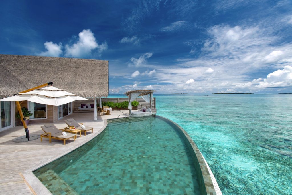 A luxurious overwater honeymoon villa with a private infinity pool at Milaidhoo Island, Maldives.