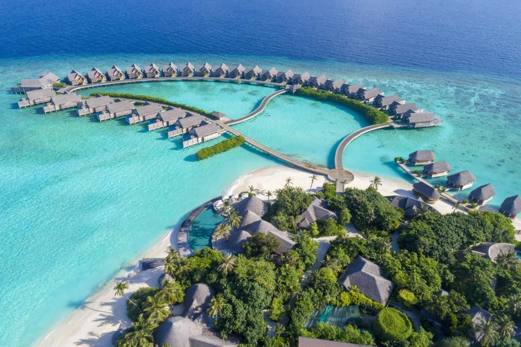 Aerial view of luxury water villas and turquoise lagoon at Milaidhoo Island Resort in Baa Atoll, Maldives.