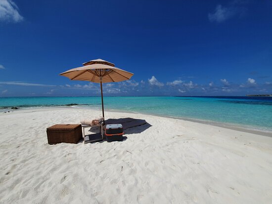 A peaceful private sandbank in the Maldives with crystal clear turquoise water, perfect for first-time visitors seeking relaxation.