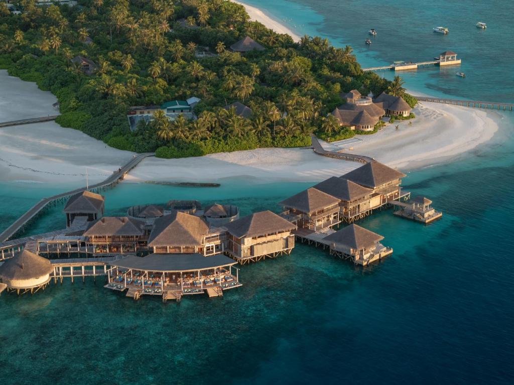 Aerial view of luxury overwater villas at Six Senses Laamu resort in Laamu Atoll Maldives, showcasing turquoise lagoon and eco-friendly architecture.