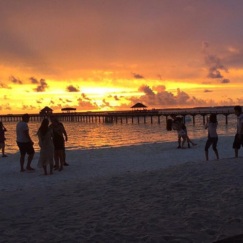 A luxury dhoni boat sailing during a golden sunset in Noonu Atoll, Maldives.