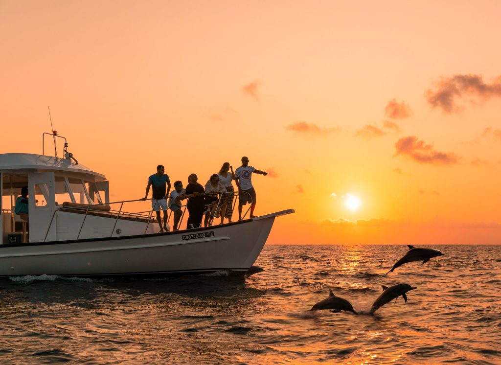 A group of tourists enjoying a sunset dolphin cruise in the Maldives, a top activity for first-time visitors.