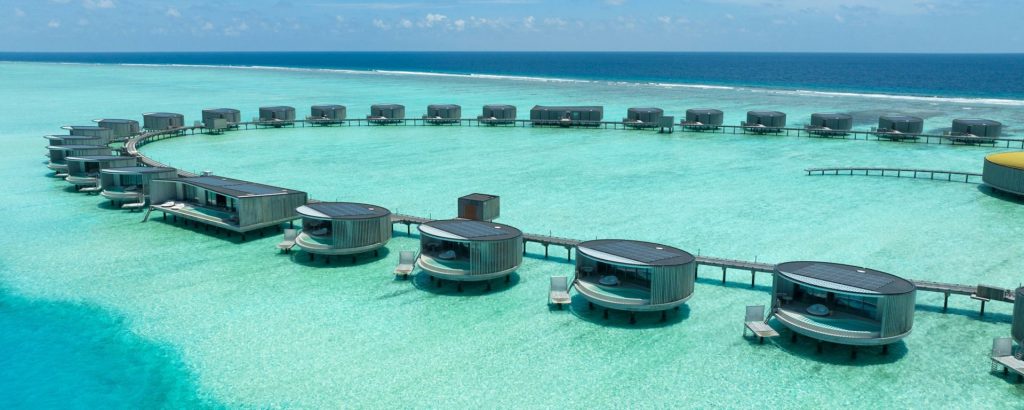 Circular overwater villas at The Ritz-Carlton Maldives Fari Islands with turquoise lagoon views for an ultra-luxury honeymoon.