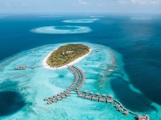 Aerial view of Vakkaru Maldives luxury resort featuring overwater villas and turquoise lagoon in Baa Atoll, a UNESCO Biosphere Reserve.
