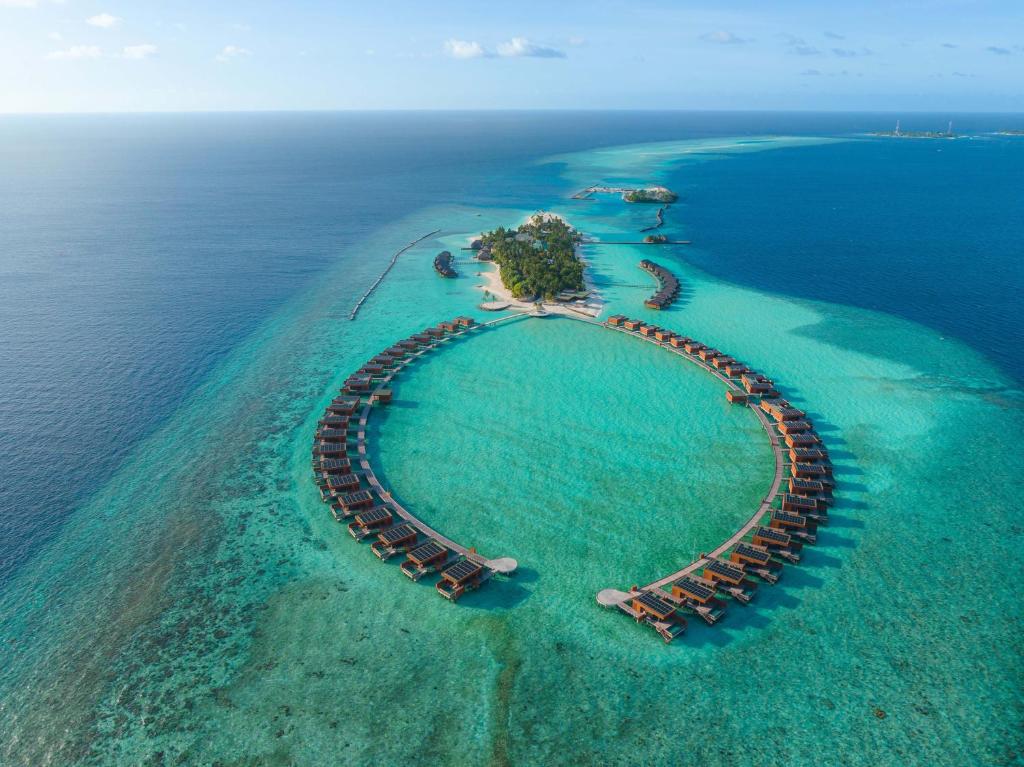 Aerial view of Veligandu Maldives Resort Island featuring luxury overwater villas and turquoise lagoon for a perfect honeymoon.