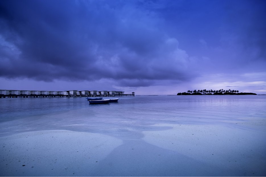 Overcast stormy sky over a luxury water villa resort in Maldives during the rainy season.