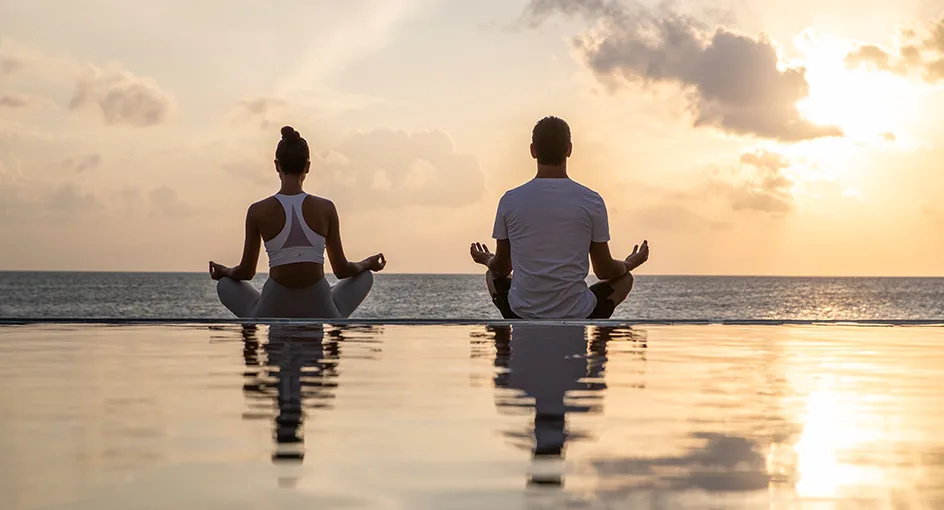 A peaceful yoga and meditation session by the ocean at a luxury resort in Noonu Atoll, Maldives.