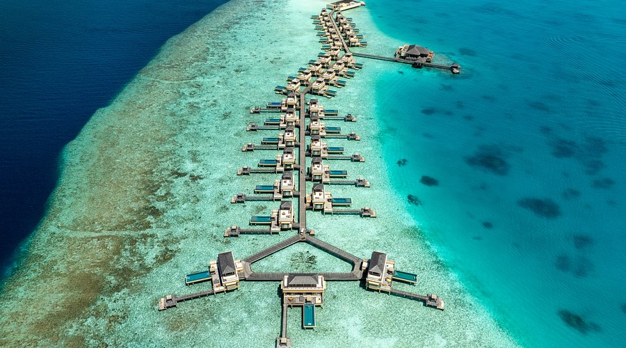 Aerial view of luxury overwater InOcean villas with private infinity pools at Angsana Velavaru Resort in Dhaalu Atoll, Maldives.