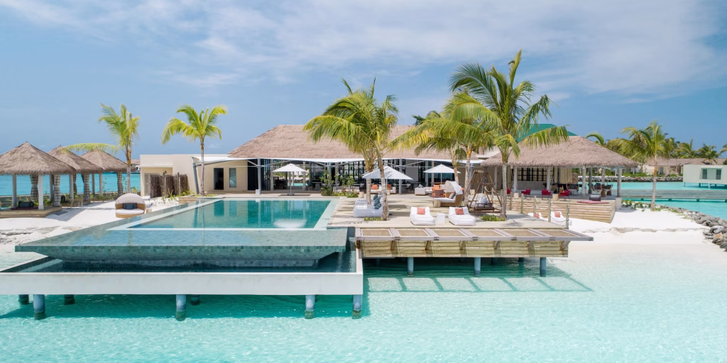 Aerial view of luxury overwater villas and turquoise lagoon at InterContinental Maldives Maamunagau Resort in Raa Atoll.