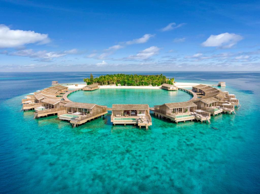 Aerial view of Kudadoo Maldives Private Island luxury overwater villas in Lhaviyani Atoll, featuring turquoise lagoons and sustainable architecture.