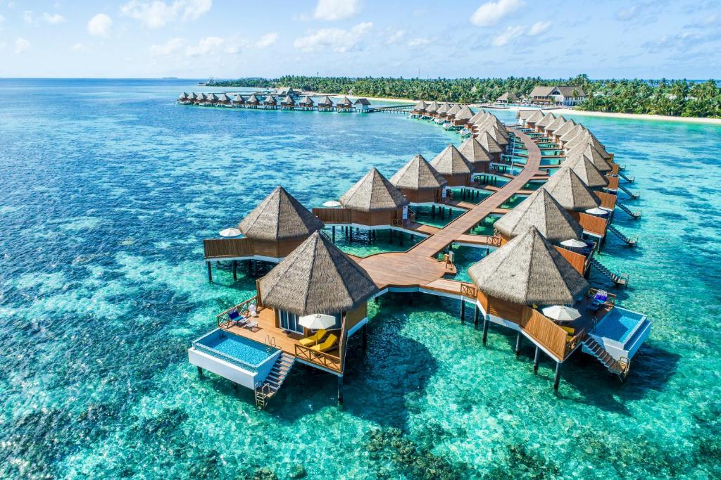 A breathtaking view of Mercure Maldives Kooddoo Resort's overwater villas and turquoise lagoon in Gaafu Alifu Atoll.