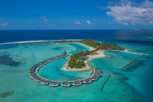 Luxury overwater villas and turquoise lagoon at COMO Maalifushi resort in Thaa Atoll, Maldives.