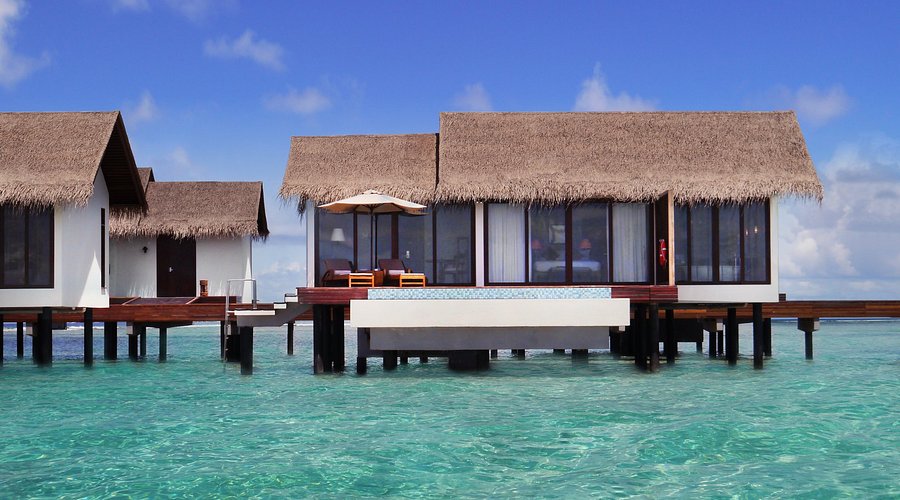 Luxury overwater villas at The Residence Maldives at Falhumaafushi in Gaafu Alifu Atoll with turquoise house reef and clear blue ocean.