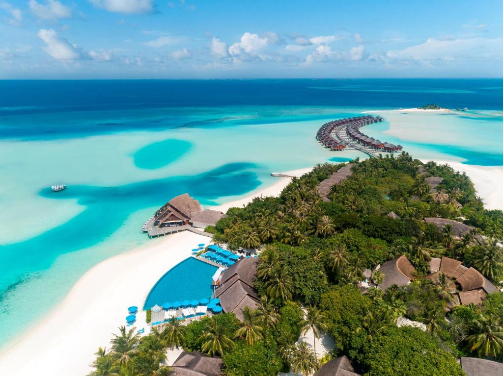 Aerial view of Anantara Dhigu Maldives Resort featuring overwater villas, turquoise lagoon, and white sandy beaches near Maafushi island.