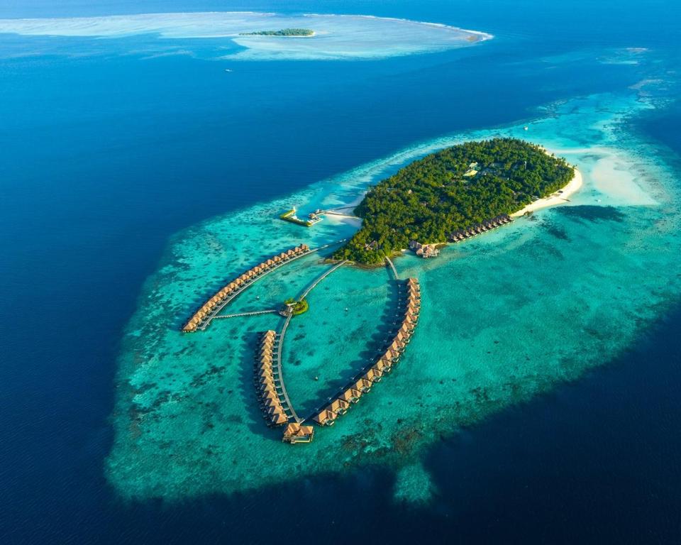Aerial view of Ayada Maldives luxury resort in Gaafu Dhaalu Atoll showing overwater villas, turquoise lagoon, and lush tropical island greenery.
