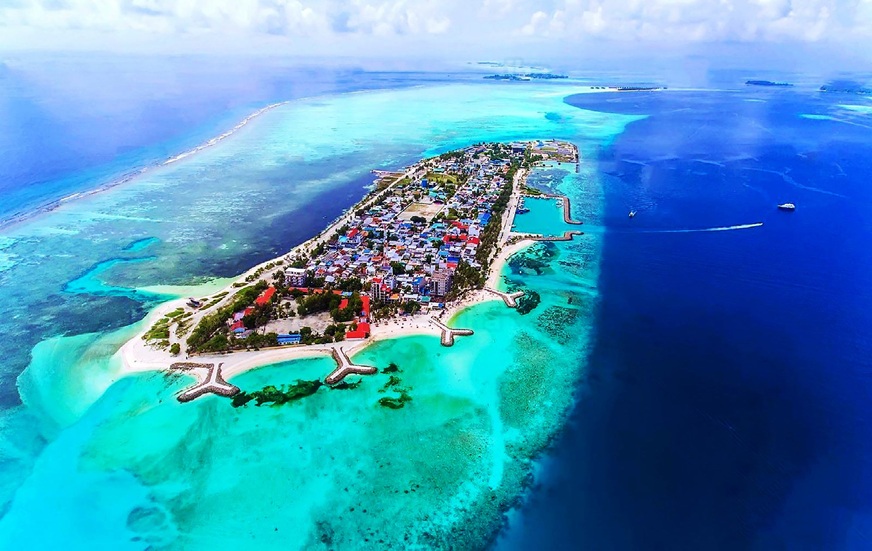 Maafushi Island bikini beach with turquoise water and palm trees, the best budget-friendly local island in Maldives 2026.