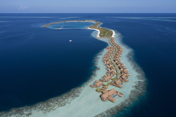 Aerial view of Waldorf Astoria Maldives Ithaafushi luxury overwater villas and turquoise lagoon near Maafushi.