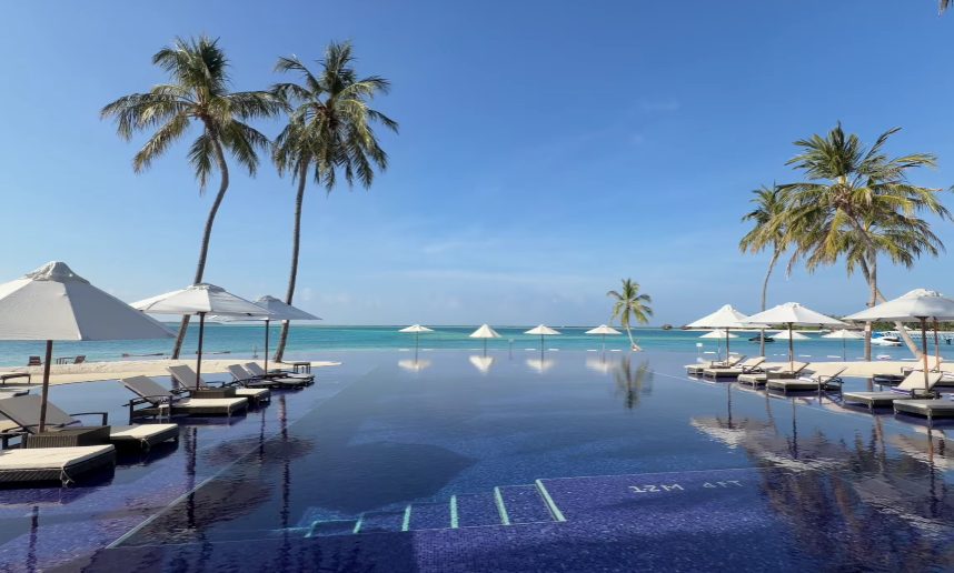 On one island, The Muraka sits within the larger Conrad Maldives Rangali setup that stretches over twin linked landmasses. To see everything around the villa, riding a bike works well.
On the central island sits the arrival hall along with the main morning dining area. Linked by a footbridge, the neighboring island holds most of the water bungalows. During this visit, one Deluxe Overwater Villa featuring its own pool served as reference. Sunlight hits the tiles just right in the washroom, giving it an edge. Standing there after leaving the Muraka changes things - no fault of the room, since under different circumstances it would impress easily though today it seems quieter somehow.
Right off the bat, the beach matches what you see in pictures. Fine white grains cover the ground beneath your feet while sunlight cuts cleanly through the shallow, warm water. What stands out most is how far you can see into the clear lagoon. Honestly, it looks like something mailed from a perfect vacation spot. That said, the sun pulls hard during the dry months, so finding shade becomes part of the routine.